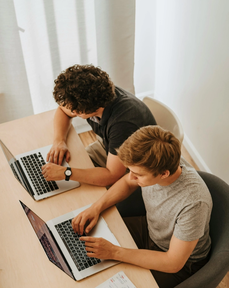 Dos personas trabajando frente a sus portátiles